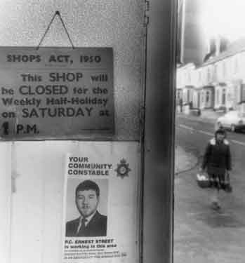 Shop door with poster for community constable, P.C. Ernest Street