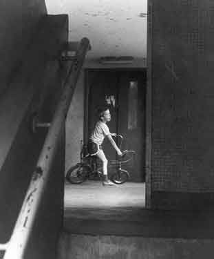 Child on chopper bicycle next to a lift entrance and staircase