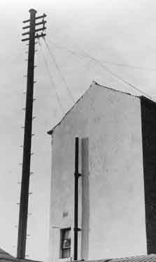 Telegraph pole and gable end of unidentified house