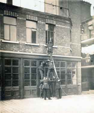 Firemen on life saving training exercise using Pompier ladder and lines, early1900's outside Rockingham Street Fire Station 