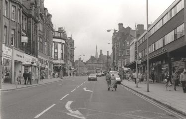 Shops on Pinstone Street looking towards (back centre) the Town Hall showing (left) Sewing and Knitting Centre; Evolution; Hearts; Extras and Abbey National Building Society