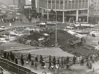 Excavations for central concourse for construction of Castle Square (also known as The Hole in the Road) showing (back centre) Peter Robinson Ltd., fashion department store and (top left) Angel Street and Horne Brothers Ltd., tailors, 1-3 King St. 