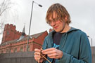 University of Sheffield Student Alix Bodin knitting outside the University House with Firth Hall in the background University of Sheffield Student Alix Bodin knitting outside the University House with Firth Hall in the background