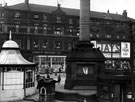 Moorhead, Passenger Transport enquiry office, drinking fountain and base of Crimean Monument in foreground, No. 2 Roberts Brothers Ltd., general drapers and Jay's Furnishing Stores, house furnishers in background