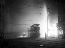 Looking across the High Street, where the flames from the King's Head Hotel have set the standing trams alight, World War II