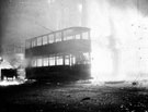 Trams on fire outside King's Head Hotel, High Street, during air raid