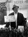 Market trader in possibly Sheaf Market showing pre-decimal price tags
