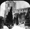 St. James C. of E. Church, Norton. Remains of the Norton Preaching Cross in foreground (man sitting at its base)