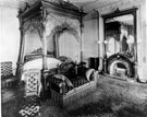 The State Bedroom on the west side of the first floor at Endcliffe Hall. The bed and couch were dressed in upholstered crimson silk damask. The mantle was inlaid walnut and marble. The large mirror decorated with a lion from Sir John Browns Coat of A
