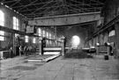 Rolling armour plates, possibly English Steel Corporation, River Don Works, Brightside Lane The material on the right, in front of the three workers, are birch twigs, used for descaling the plates during rolling