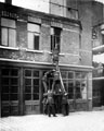 View: s12496 Firemen on life saving training exercise using Pompier ladder and lines, early 1900's outside Rockingham Street Fire Station