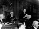 View: s12592 City Council in session, Alderman Harold Warters Jackson (1883 - 1972), leader of the opposition, speaking, Lord Mayor, Ernest Storm Graham, centre, Alderman C.W. Gascoigne, left, town clerk, Mr John Heys, (foreground,extreme right)