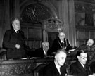 View: s12593 City Council in session, Alderman Frank Thraves, C.B.E., J.P., chairman of the Watch Committee, speaking, Lord Mayor, Alderman C.W. Gascoigne, Deputy Lord Mayor, centre, Ernest Storm Graham, right