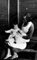 Mother and baby on a verandah of a munitions hut in Tinsley, considered a very good place to live, only Munition Workers could live there. Built to last 3 years actually lasted 30 years