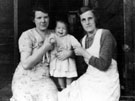 Two women and a child inside the married quarters of the munitions huts, Tinsley