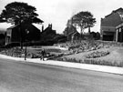 Flower and rock garden (former site of Pear Tree Cottages), in front of S.Y.D Laundry offices and van store, old Shiregreen Church School (background), Bellhouse Road, Shiregreen