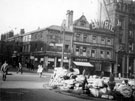 View: s15567 Town Hall Square and Fargate looking towards Leopold Street, including No. 70 Sheffield Creameries Ltd. (corner of Leopold Street) and No. 68 Loxley Brothers Ltd., printers, No. 66 Fleur de Lis public house, (Bovril sign)