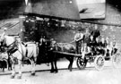 Two horse brewers dray probably part of May Day parade in Bridge Street just before Corporation Street with the cementation furnaces belonging to Millsands Steel works in the background