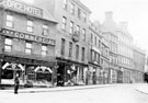 High Street from Market Place, before the street widening of 1896, No. 68, Market Place, Charles Butler, confectioner, No 70, George Hotel, No 64A, High Street, India Rubber, Gutta-Percha Ltd., No 52-56 John Walsh, draper, Clarence Hotel in backgroun