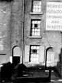 Back to back, No. 45 Fowler Street, Burngreave, showing the sign for off-license at No. 47, picture shows the steep, dark, narrow passage to gain access to yard, W.C's and ash bins