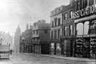View: s17221 Market Place, High Street, (corner with Change Alley), No. 72 Capital and Labour Clothing Assoc., No. 74 Geo. Thos. Wilkinson Newsholme, chemist, No. 76, W.F. Rodgers Ltd., printers, Nos. 78 - 80 John Wheeldon and Co., manufacturers of leather goods
