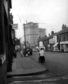 London Road from outside Nos. 154 - 174 Frank B. Roper Ltd., motor cycle dealers, left, construction of Lansdowne Flats in background