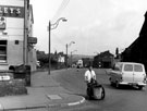 Road sweeper on Penistone Road at the junction with Owlerton Green with St. John the Baptist, Owlerton and Old Crown Inn (right) and Sportsman's Group public house (left)