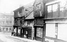 Snig Hill looking towards West Bar, derelict timber framed shops, prior to demolition in 1900. Pack Horse Hotel, West Bar, in background