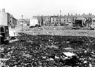 View: s20892 Demolition of housing around the Headford Street area. Headford Street (including Dog and Gun public house with black car), left, looking towards derelict back to back housing on Bath Street, prior to demolition. Empty street in foreground is Egerton