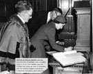 Princess Margaret signs the visitors book at the Town Hall. Lord Mayor, Alderman William Ernest Yorke, looks on