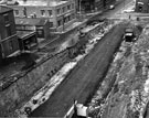 View: s23050 Construction of Eyre Street outside Arnold Carter and Co. Ltd., builders and plumbers merchants, Trinity Works and T.C. Vere Ltd., basket manufacturers showing the junctions with Duke Lane and Matilda Street