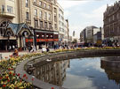 View: s23333 The Goodwin Fountain, entrance to Orchard Square and Dixons Ltd., photographical equipment; audiovisual and  electronics store, Fargate looking towards Kemsley House, High Street