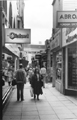 View: s23831 Shoppers in Chapel Walk showing No. 37 Charles Clinkard, shoe shop with the Crucible Theatre in the background