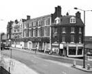View: s23955 Nos. 18, The Corner Cafe, Snack Bar; 20 and  22/34, former premises of Turner and Son Ltd., wholesale newsagent, stationers etc. (22-26 formerly Blue Boar public house), West Bar with Spring Street extreme right