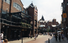 View: s24033 Orchard Square looking towards Fargate showing Sherratt and Hughes, book shop; The Body Shop and one face of the Clock Tower with the striking bells