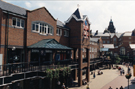View: s24034 Elevated view of Orchard Square looking towards Fargate showing Sherratt and Hughes, book shop; The Body Shop and one face of the Clock Tower with the striking bells