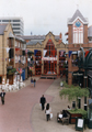 View: s24039 Orchard Square Shopping Centre decorated with banners for the European Football Championships looking towards the Food Court and showing The Hogshead public house; The Body Shop; Clock  and Housing for the Automaton