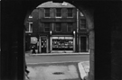 View from an Archway at the rear of the Town Hall looking across Norfolk Street to the archway to Cadman Lane; No. 131, Wm, Leslie Gould, optician and the doorway of No. 133