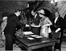 Colin Straw, secretary to the Lord Mayor, handing a pen for Queen Elizabeth II and HRH Duke of Edinburgh to sign the visitors book in the Town Hall with Lady Mayoress Mrs. Richardson in the background