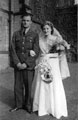 Bride and groom, possibly connected to James Dixon. Groom wears Air Force uniform and the bride wears white gown and gloves and carries yellow flowers