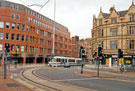 Traffic lights at the junction of West Street and Leopold Street with Supertram travelling on Church Street