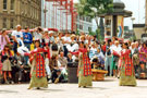 View: t04687 Tibetan Dance Team, Fargate with Barkers Pool in the background during the World Student Games Cultural Festival 
