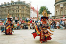 View: t04689 Tibetan Dance Team, Fargate with Pinstone Street (left) and Barkers Pool in the background during the World Student Games Cultural Festival 