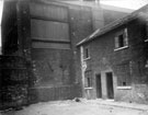 View: u00457 Wall belonging to Batty Langley's, timber merchant, Sheaf Saw Mills, off River Lane, showing wall plates, from Mate's Square, off River Lane, (showing slum housing on right)