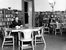 Three readers at a table in the adult section of Ecclesall Library, Knowle Lane (former Weetwood House)