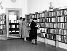 Three ladies at the shelves in front of the display case, Ecclesall Library (former Weetwood House), Knowle Lane Three ladies at the shelves in front of the display case, Ecclesall Library (former Weetwood House), Knowle Lane