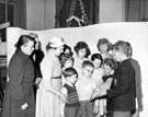 Mrs. Thorpe, wife of Chairman of Libraries, Art Galleries and Museums Committee, Coun. Mrs. Jowett and Coun. Mrs. Goldring with John Pilley holding award for best decorated Childrens Library, Firth Park Branch Library, Christmas 1958