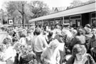 Children meeting Postman Pat outside bowling pavilion, Firth Park with Firth Park Road in the background