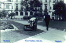 Gardener at work in the Peace Gardens with The Town Hall in the background Gardener at work in the Peace Gardens with The Town Hall in the background