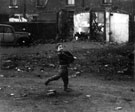 Child playing among the dereliction in an unidentified area Child playing among the dereliction in an unidentified area